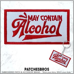 May include: A white rectangular patch with red embroidered text that reads "MAY CONTAIN Alcohol". A matching keychain with the same design is also visible. The patch and keychain have a red border.