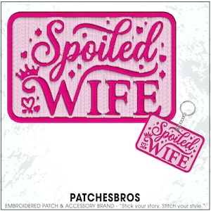 May include: A pink embroidered patch and keychain set with the words "Spoiled WIFE" in a script font. The patch and keychain have a rectangular shape with a crown and heart design. The brand name "PATCHESBROS" is at the bottom.