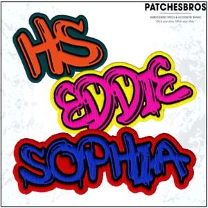 May include: Embroidered patches with graffiti-style lettering. The patches feature the names "HS", "Eddie", and "Sophia" in vibrant colors. The "HS" patch is orange with a dark green outline. The "Eddie" patch is pink with a yellow outline. The "Sophia" patch is blue with a red outline.