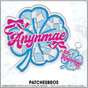 May include: Embroidered clover patch and keychain with the name "Anynmae" in pink script. The clover design features a blue and white checkered pattern, outlined in blue and white stitching. The keychain has a silver ring.
