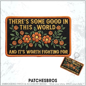 May include: A rectangular embroidered patch with a black background and orange border. It features orange flowers with green leaves and the yellow text: THERE'S SOME GOOD IN THIS WORLD AND IT'S WORTH FIGHTING FOR. A matching keychain is also included.