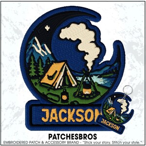 May include: An embroidered patch and matching keychain featuring a crescent moon shape containing a camping scene with a yellow tent, a campfire, pine trees, and mountains. The name JACKSON is stitched in yellow letters on a blue rectangular base.