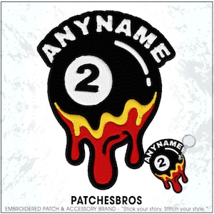 May include: An embroidered patch and a matching keychain featuring a black billiard ball with the number 2 in a white circle. The design includes yellow and red liquid-like drips at the bottom and the text ANYNAME arched in white at the top.