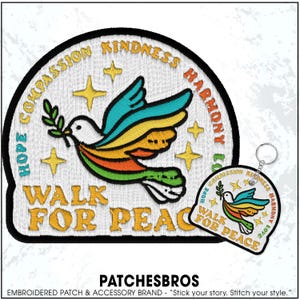 May include: Embroidered patch and keychain featuring a colorful dove carrying an olive branch. The patch and keychain have the words "HOPE COMPASSION KINDNESS HARMONY LOVE" and "WALK FOR PEACE" in gold lettering.