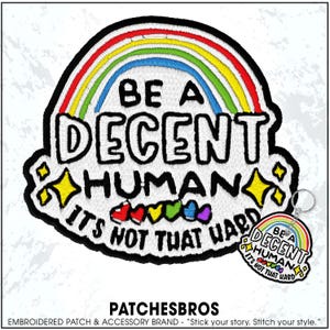May include: Embroidered patch with a rainbow design and the text "BE A DECENT HUMAN, IT'S NOT THAT HARD." Includes a matching keychain. The patch features a black border, yellow stars, and colorful hearts.