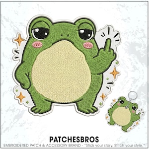 May include: An embroidered patch and a matching keychain featuring a green frog with a cream-colored belly, pink cheeks, and large black eyes. The frog is depicted with one hand raised, showing a middle finger gesture, surrounded by small orange stars.