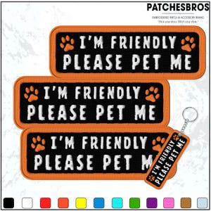 May include: Embroidered patches and a keychain with the text "I'M FRIENDLY PLEASE PET ME" in white on a black background, framed by an orange border. The patches and keychain feature orange paw prints.