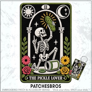 May include: A rectangular embroidered patch and matching keychain featuring a skeleton kneeling under an archway, holding a green pickle. The design includes a sun, moon, stars, and flowers in pink and yellow, with the text THE PICKLE LOVER.