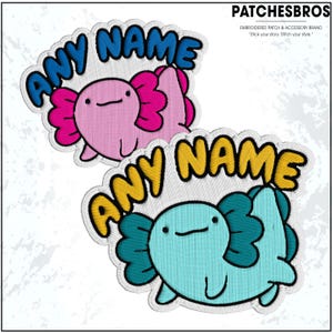 May include: Embroidered patches featuring axolotl designs in pink and teal, each with the text "ANY NAME" in a bubble font. The patches are outlined in white and have a stitched texture. The brand name "PATCHESBROS" is visible.