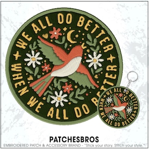 May include: Embroidered patch and keychain set with a bird design. The patch and keychain feature a bird with orange, green, and white details, surrounded by flowers, a crescent moon, and the text "WE ALL DO BETTER WHEN WE ALL DO BETTER."