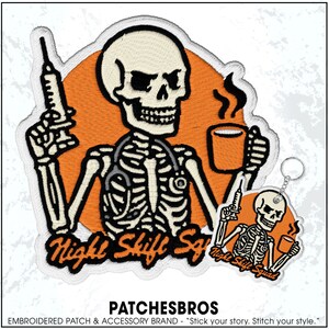 May include: Embroidered patch featuring a skeleton with a stethoscope, holding a syringe and a coffee mug. The patch has the text "Night Shift Squad" and is set against an orange background. A smaller keychain version is also included.