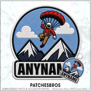 May include: A circular embroidered patch and a matching circular keychain featuring a skydiver in a red jacket and tan pants descending with a red parachute over dark blue mountains and white clouds against a light blue sky, with the text ANYNAME.