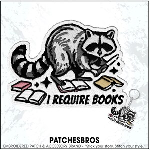 May include: Embroidered patch featuring a raccoon holding a knife, surrounded by books. The text "I REQUIRE BOOKS" is below the raccoon. A small keychain with the same design is also visible. The brand name "PATCHESBROS" is at the bottom.