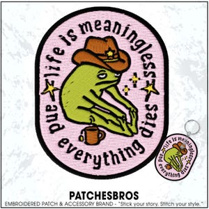 May include: Embroidered patch with a green frog wearing a brown cowboy hat, with the text "and life is meaningless everything dies" in a pink oval. A matching keychain is also visible.