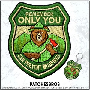 May include: Embroidered patch featuring a bear in a ranger uniform holding an axe, with the text "REMEMBER ONLY YOU CAN PREVENT WILDFIRES." A matching keychain is also shown. The patch is green, brown, and tan.