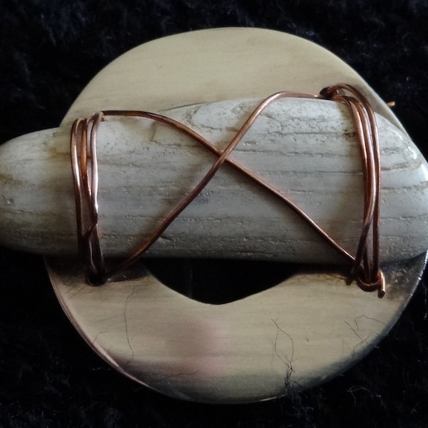 Hand-made brooch in a sterling silver circle with a piece of petrified wood secured by copper wire