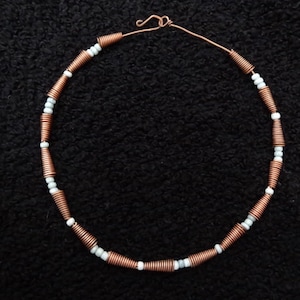 Hand made choker made of copper wire cones and pale blue ceramic beads strung on a copper wire