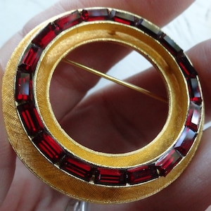 Vintage lovely circle brooch with baguette cut deep red glass stones