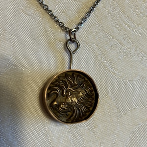 Pendant necklace with with vintage Terrier dog brass buttonin a copper enclosure on a silver tone metal chain