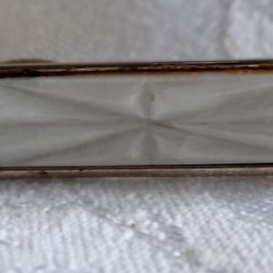Silvertone tie bar of faux carved mother of pearl