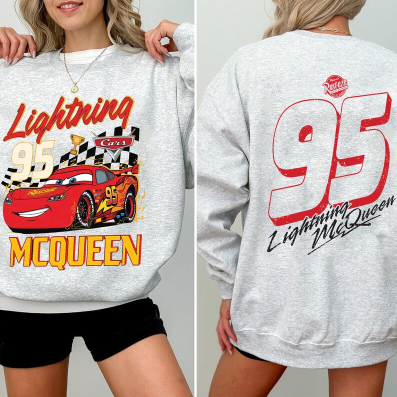 Puede incluir: Una sudadera gris claro con Lightning McQueen de la pel&iacute;cula Cars. El frente muestra a McQueen, el n&uacute;mero 95, una bandera a cuadros y las palabras "Lightning" y "McQueen". La parte trasera muestra un gran n&uacute;mero 95 rojo y "Lightning McQueen."