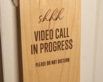 Letrero de madera para puerta con videollamada en curso