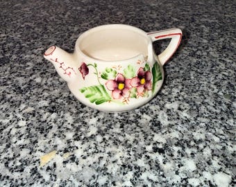 Tetera vintage sin marca, posacucharas, plato pequeño de cerámica color crema con estampado floral.