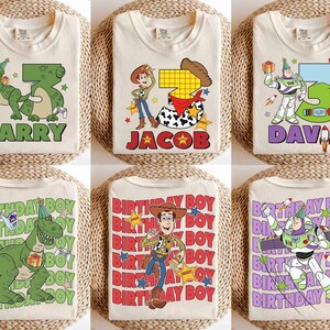 May include: Cream-colored t-shirts with colorful graphics featuring cartoon characters and the names "LARRY", "JACOB", and "DAVID". The shirts have birthday-themed designs with the text "BIRTHDAY BOY".