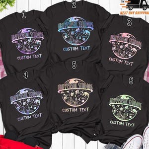 May include: Black t-shirts with a Universal Studios graphic design. Each shirt features the Universal Studios logo above a circular design with various icons and the text "CUSTOM TEXT" below. The logo and design colors vary.