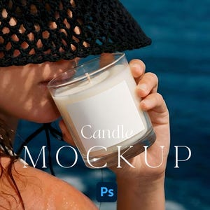 May include: A clear glass candle holder with a white candle and a blank white label. The candle is held by a person wearing a black hat. The words "Candle MOCKUP" are printed on the image.