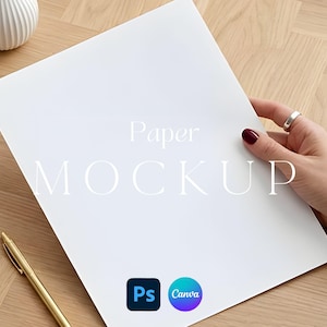 May include: A white paper mockup with the text "Paper MOCKUP" is held by a hand with a silver ring and dark red nail polish. A gold pen and a white vase are on a wooden surface. The image includes the Photoshop and Canva logos.