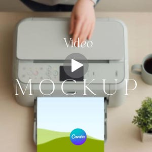 Op de afbeelding: Een lichtgrijze desktop-printer met een papierlade die een vel papier bevat met een groene landschapsafbeelding en het Canva-logo. De printer heeft een bedieningspaneel met knoppen en een klein scherm, met de tekst Video MOCKUP eroverheen.