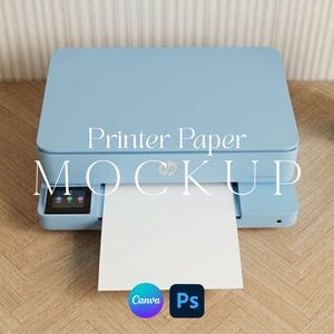May include: A light blue desktop printer with a sheet of white paper extending from the front tray. The text Printer Paper MOCKUP is centered on the device. Two small circular icons for Canva and Photoshop are positioned at the bottom center.