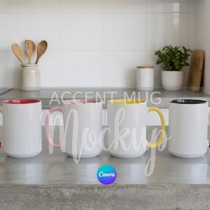 May include: Four white accent mugs with coloured interiors and handles: red, pink, yellow, and black. The mugs are on a grey countertop, with kitchen utensils and plants in the background.