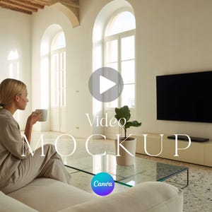 Könnte beinhalten: Eine Frau in beiger Kleidung sitzt auf einem weißen Sofa und hält eine Tasse. Ein großer schwarzer Fernseher ist an der Wand montiert. Die Worte "Video Mockup" werden auf dem Bild zusammen mit einem Canva-Logo angezeigt.