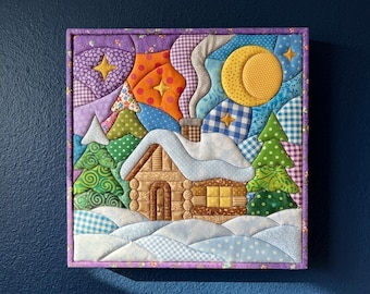 Könnte beinhalten: Ein quadratischer Wandbehang aus Stoff mit einer gesteppten Winterszene, die eine schneebedeckte Blockhütte und grüne, gemusterte Tannen zeigt. Der Nachthimmel ist mit einem gelben Halbmond, Sternen und bunten Stoffstücken in Lila und Orange gestaltet.