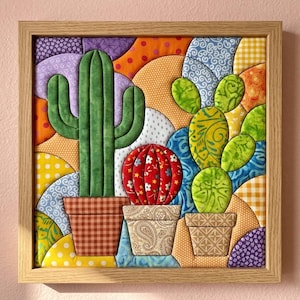 May include: A square framed fabric wall art piece featuring three potted cacti. The cacti are rendered in green and red fabric with various patterns. The pots have brown, beige, and tan textures. The background consists of colorful fabric arcs.