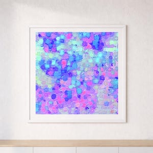 Peut inclure: Impression d'art abstrait dans un cadre blanc. L'œuvre présente un motif coloré et texturé avec un mélange de teintes bleues, violettes, roses et vertes. L'œuvre est accrochée à un mur blanc au-dessus d'une surface en bois.