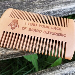 Peut inclure: Un peigne &agrave; barbe en bois avec une silhouette de Dark Vador et le texte "Je trouve votre manque de barbe d&eacute;rangeant".