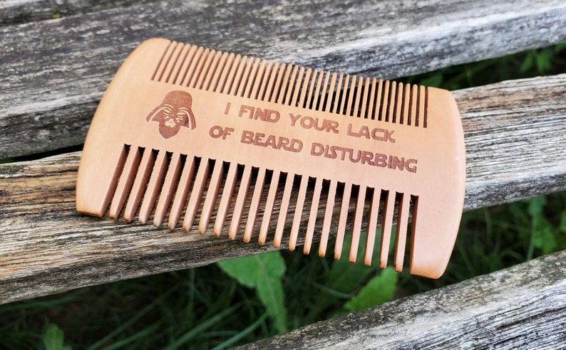 Peut inclure: Un peigne &agrave; barbe en bois avec une silhouette de Dark Vador et le texte "Je trouve votre manque de barbe d&eacute;rangeant".