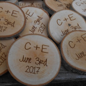 May include: A close-up of several wooden round slices with the text "C+E June 3rd 2017" engraved on them.