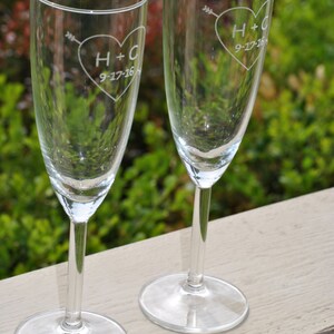 May include: Two clear glass champagne flutes with etched hearts and the initials H+C and the date 9-27-16.