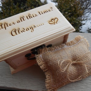 May include: A wooden ring box with the inscription "After all this time? Always..." and two hearts. The box is open and a burlap ring pillow is inside.