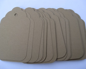 May include: A stack of brown paper gift tags with scalloped edges and a hole punched at the top.