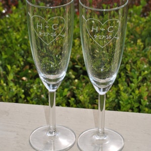 May include: Two clear glass champagne flutes with etched hearts and the initials "H+C" and the date "9-17-16".