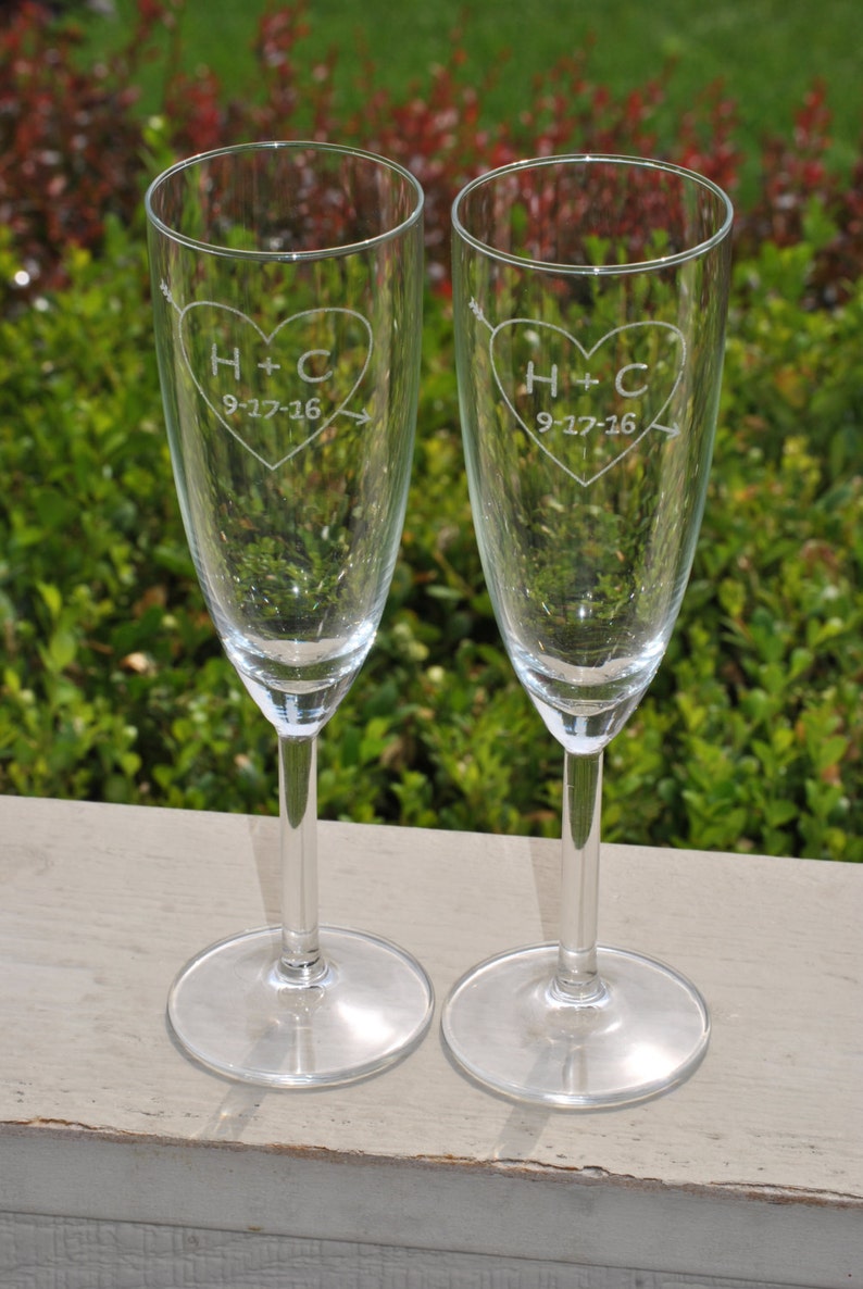 May include: Two clear glass champagne flutes with etched hearts and the initials "H+C" and the date "9-17-16".
