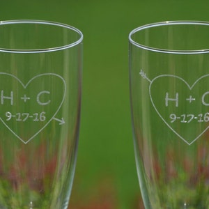 May include: Two clear glass champagne flutes with etched hearts and the initials H+C and the date 9-17-16.