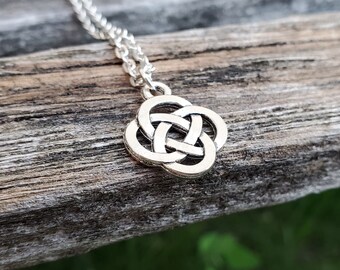 Puede incluir: Un collar de plata con un colgante de nudo celta. El nudo es un símbolo tradicional de amor, amistad y eternidad.