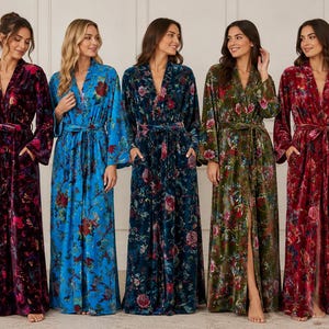 Pode incluir: Cinco roupões de veludo que vão até ao chão, com mangas compridas, cinto para atar e bolsos laterais. Cada roupão apresenta um padrão floral distinto em várias cores, incluindo roxo profundo, azul brilhante, azul-petróleo, verde-azeitona e vermelho.