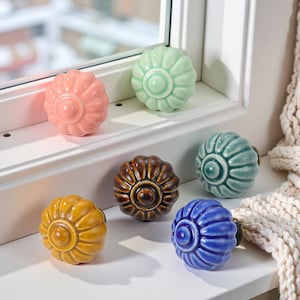 Puede incluir: Colección de seis pomos de cerámica para armarios en varios colores, incluyendo rosa, verde, marrón, amarillo, turquesa y azul. Cada pomo tiene un diseño floral y un acabado brillante, ideal para muebles.